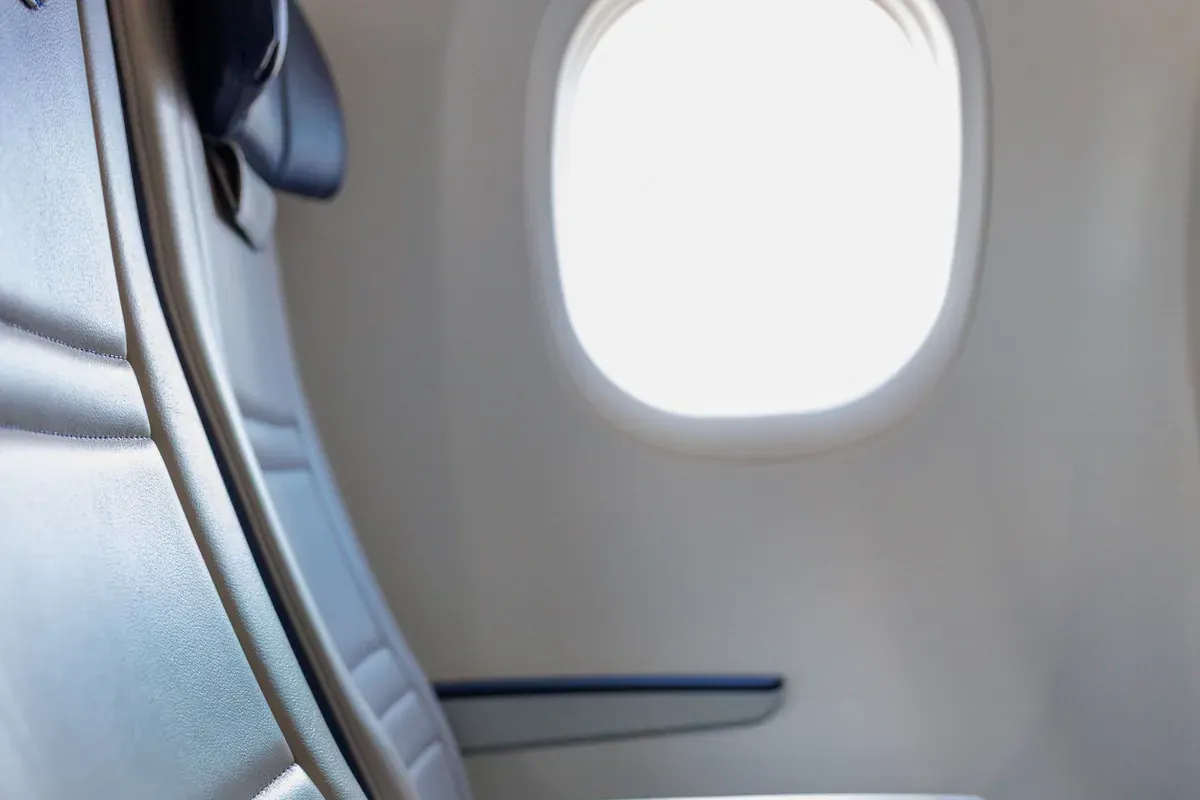 Un hublot d'avion laissant entrer la lumière du jour dans la cabine