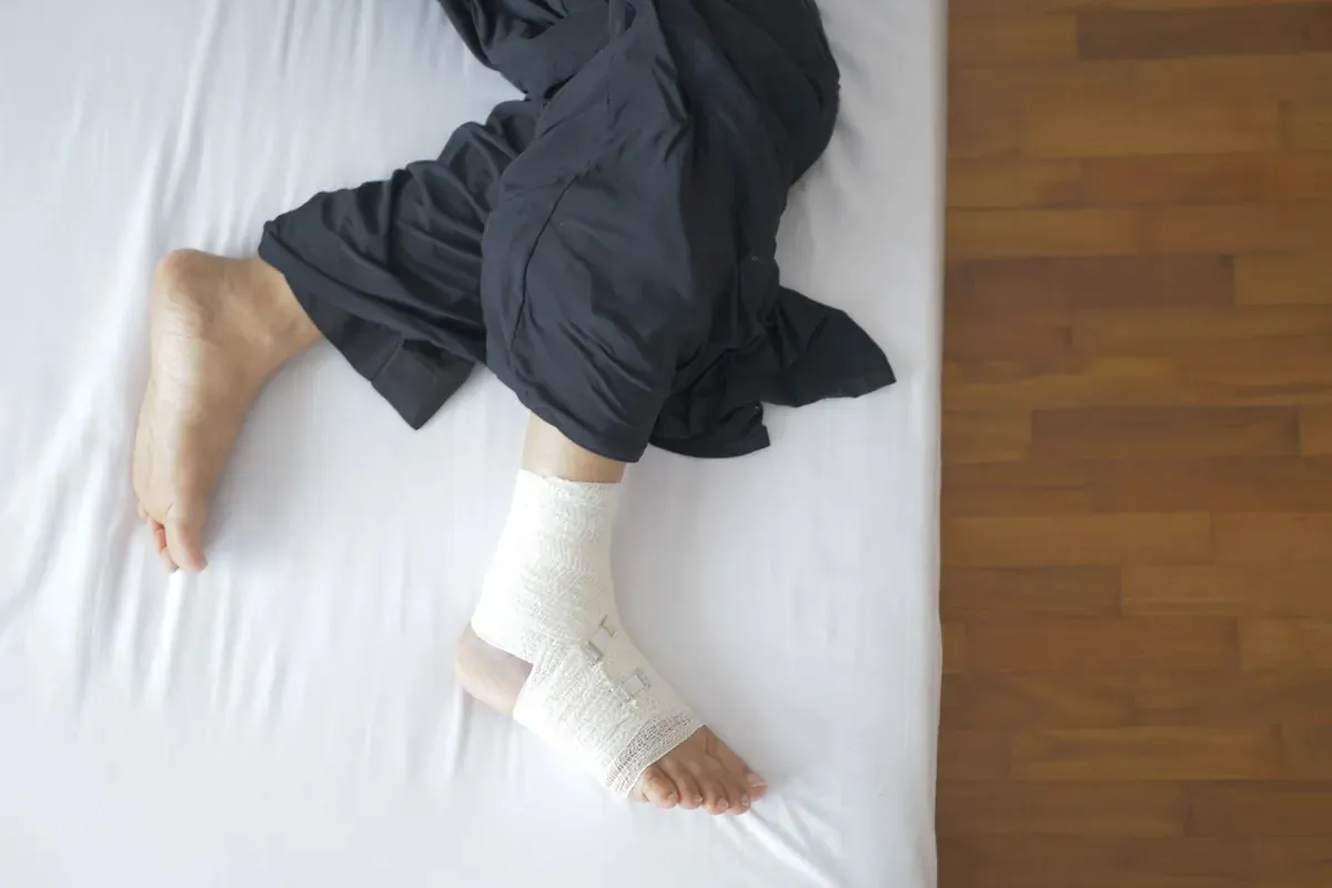 Un pied bandé posé sur un lit