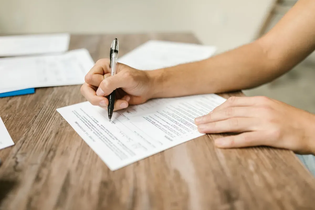 Une personne remplit un formulaire à un bureau