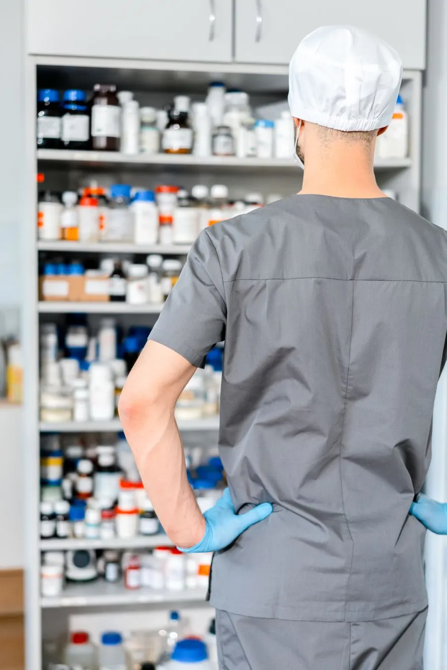 Un pharmacien prépare des médicaments devant les rayons