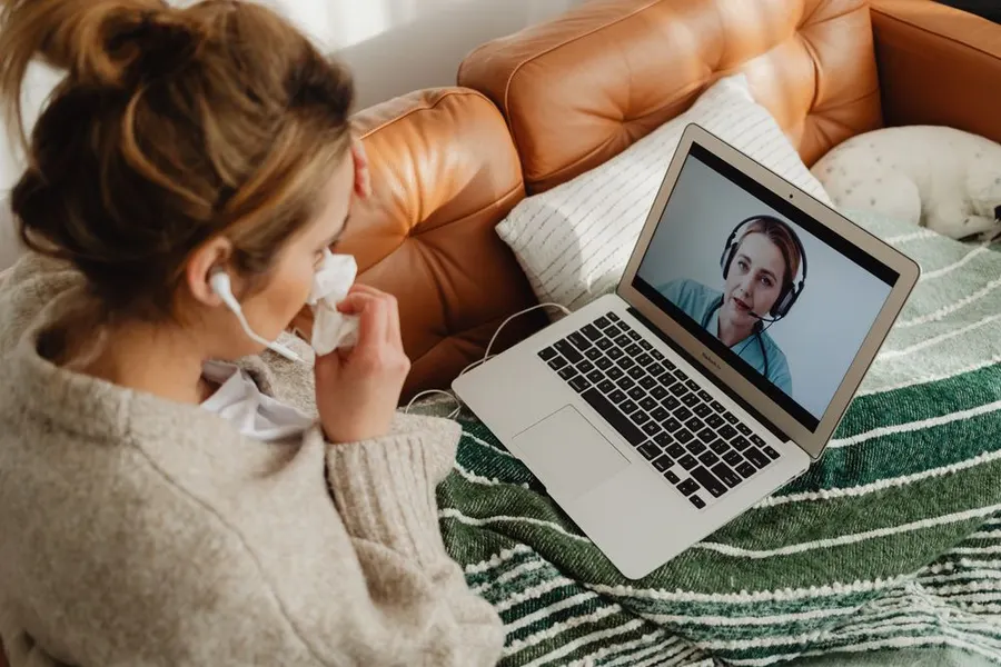 Une voyageuse en consultation vidéo depuis son canapé