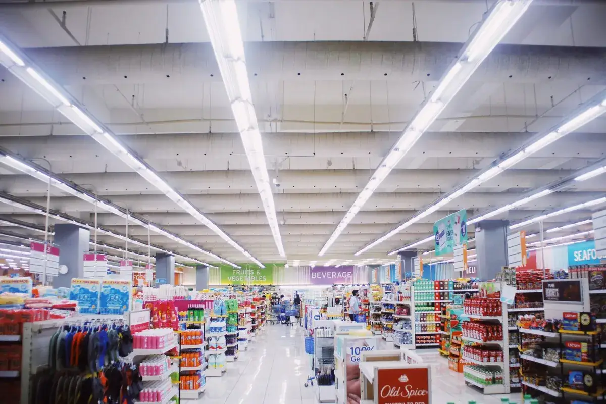 Une allée de drugstore vivement éclairée, bordée de produits