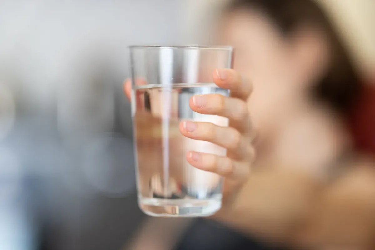 Une main tenant un verre d'eau