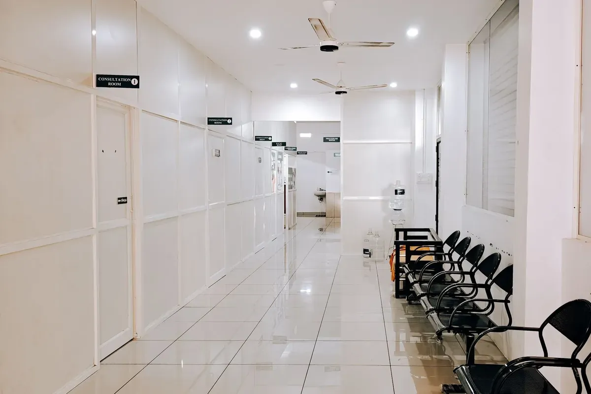 Un couloir d'hôpital désert bordé de chaises d'attente